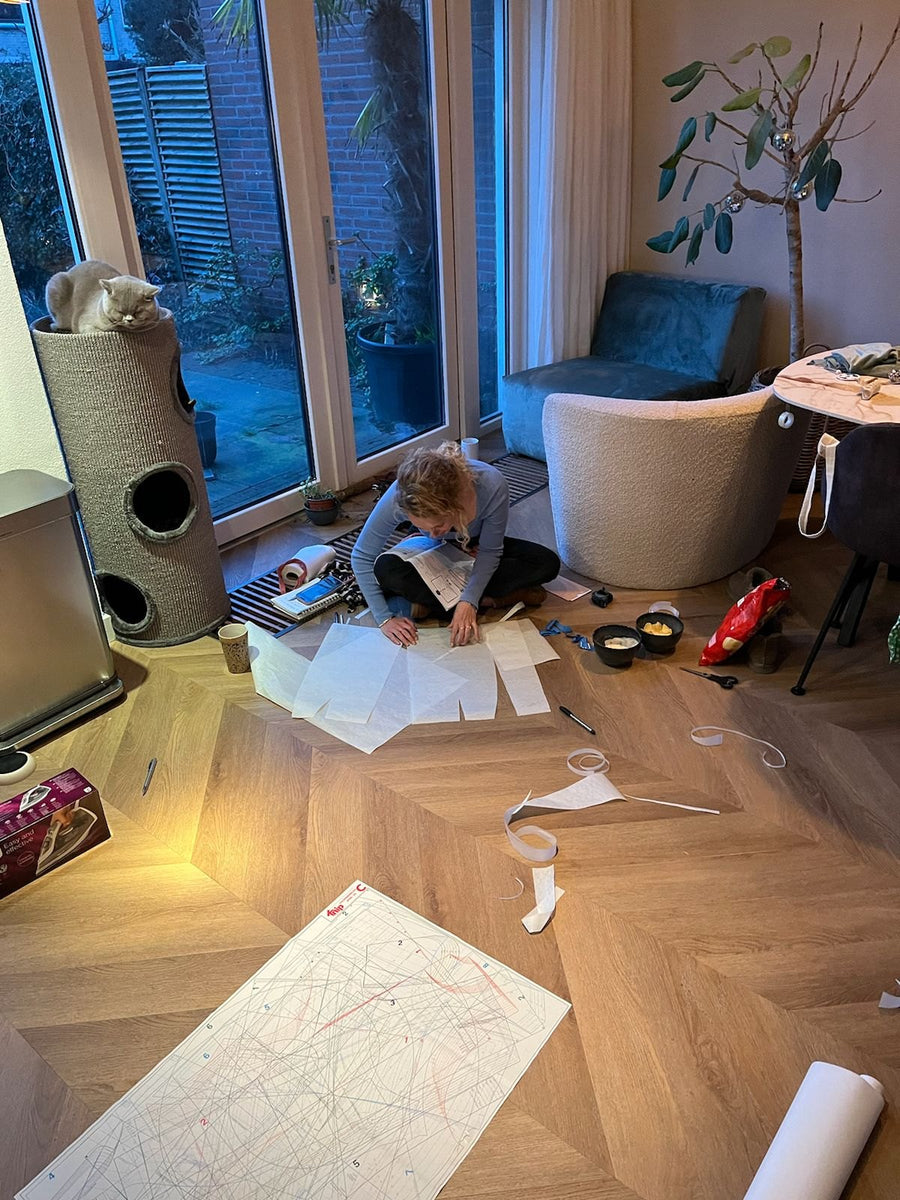 Drawing and cutting out sewing patterns on the living room floor